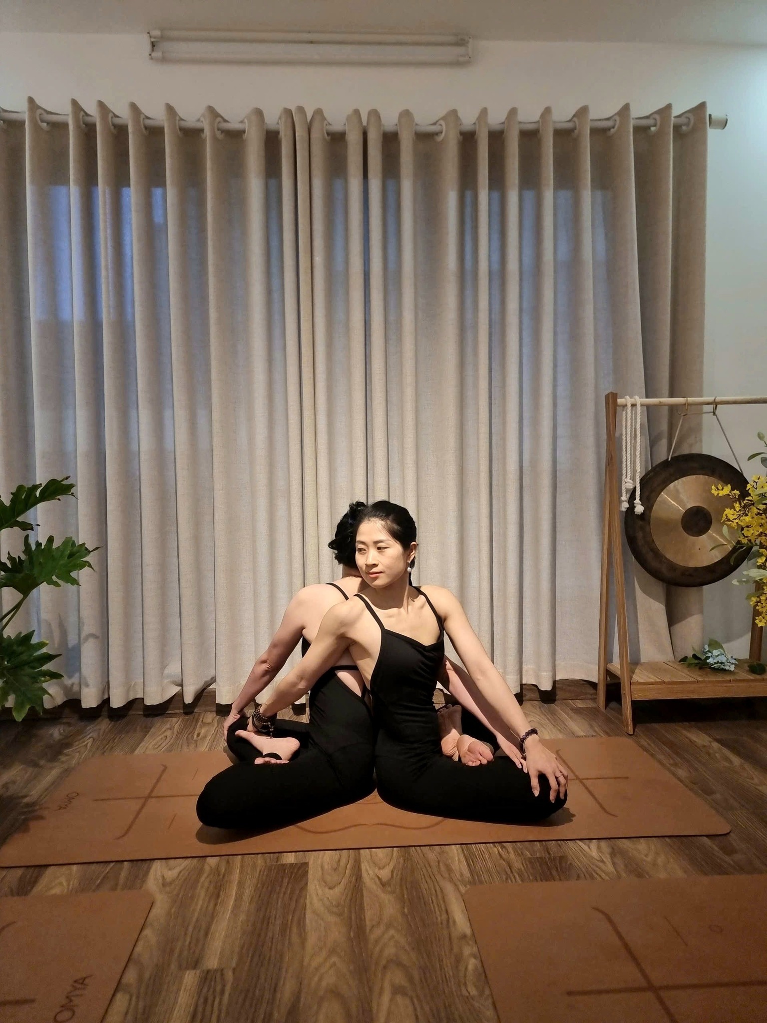 Chuông ngân và thảm yoga trong phòng tập ánh sáng ấm tại Metta Singing Bowl